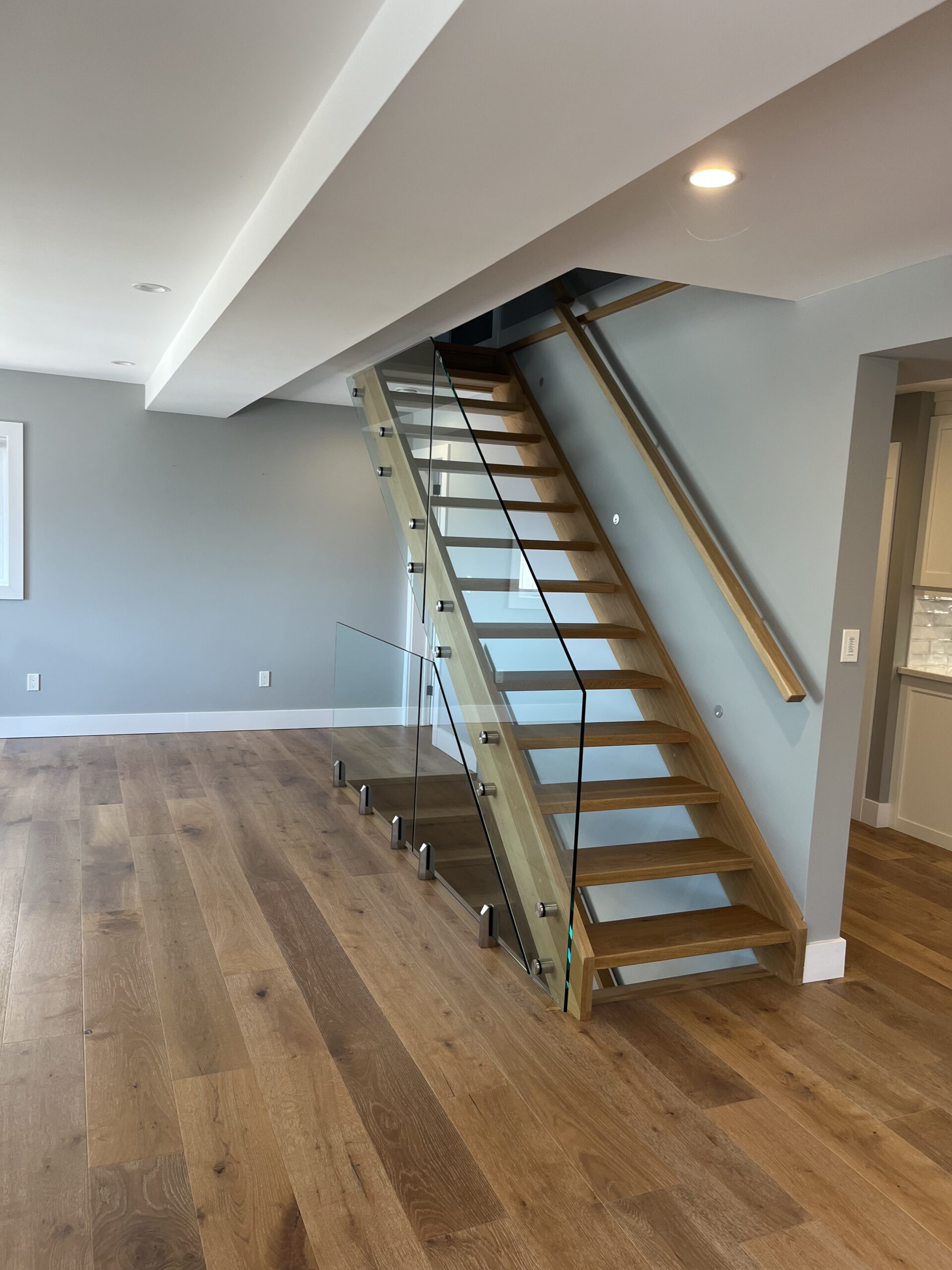 Custom open riser staircase with glass railing