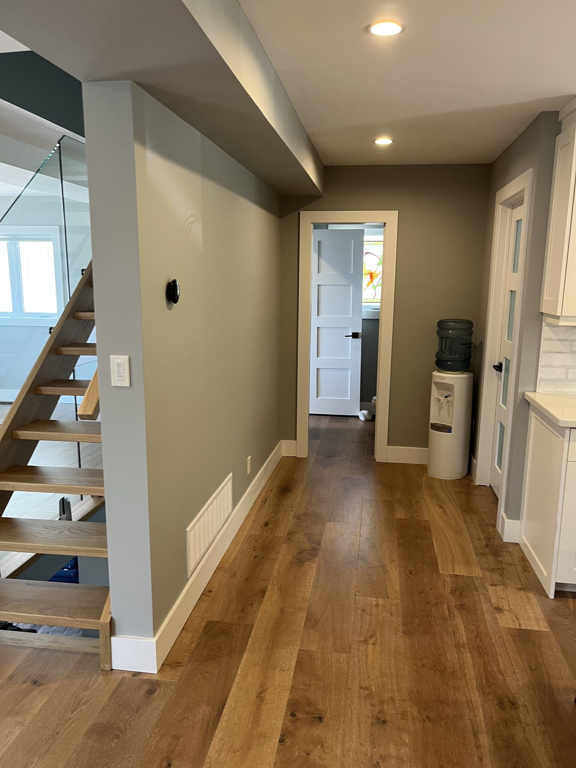 Newly installed wide plank hardwood flooring in a hallway